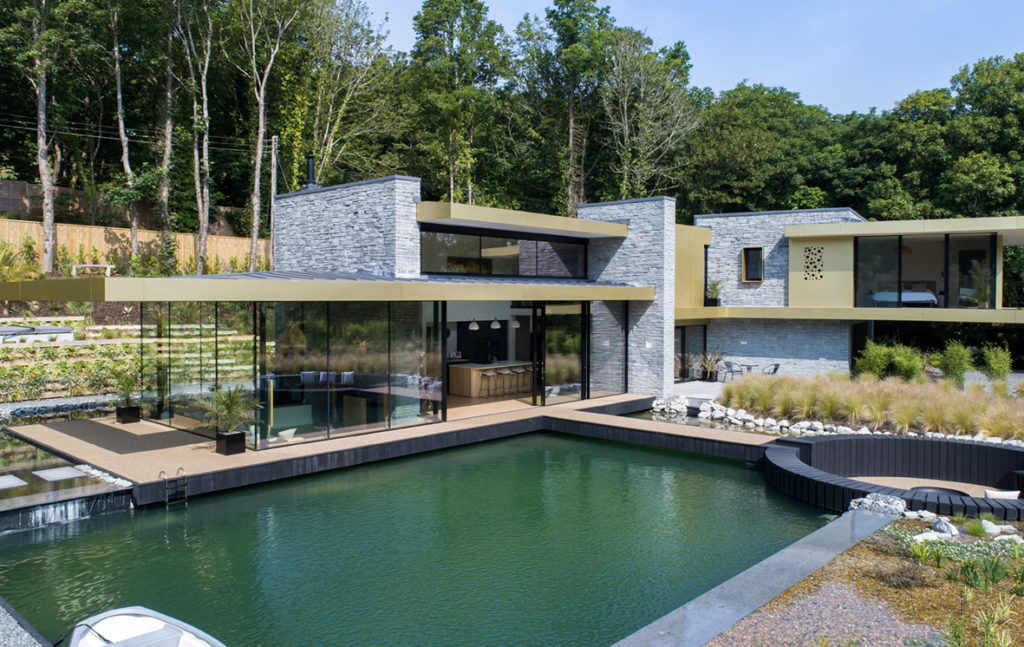 Walls of glass 3 metres high surrounding a living area with view of pool