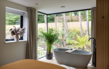 A bath with a view, black framed corner windows