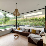 Glass walls and doors with black frames define the surroundings